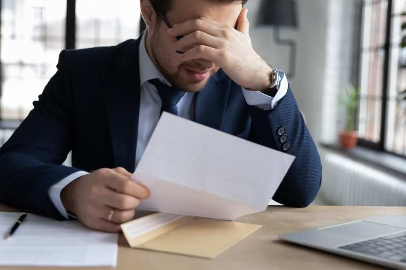 A man appears upset as he reads a notice of unfair disciplinary procedures against him