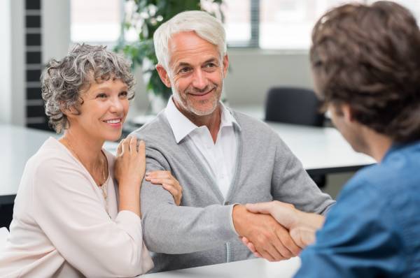 An elderly couple receive advice from a lawyer about power of attorneys during a consultation