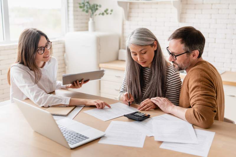 A middle aged couple receive advice from a family law solicitor during a consultation