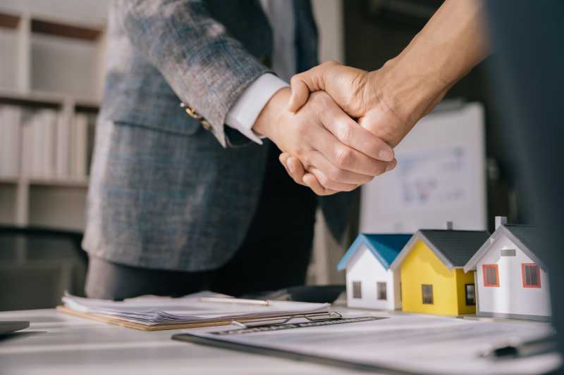 Two businessmen shake hands after resolving a property dispute