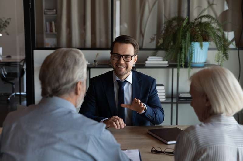 A smiling solicitor gives employment legal advice to his clients during a consultation.